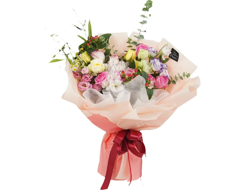 Mixed bouquet of pink and yellow roses, purple-edged lisianthus and red berries in peach wrapping paper with a burgundy ribbon