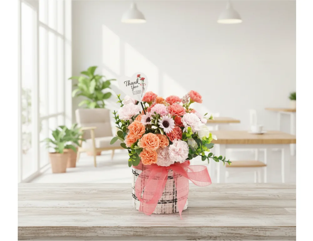 Giỏ hoa xà phòng Sweet Peach Pink trên bàn gỗ trong căn phòng sáng kiểu quán cà phê với cây xanh và ghế phía sau