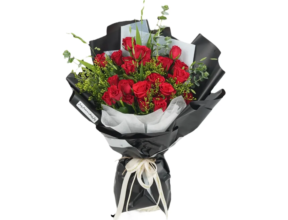 Bouquet of red roses with yellow solidago, eucalyptus and grasses in black wrapping with white inner paper and a cream ribbon