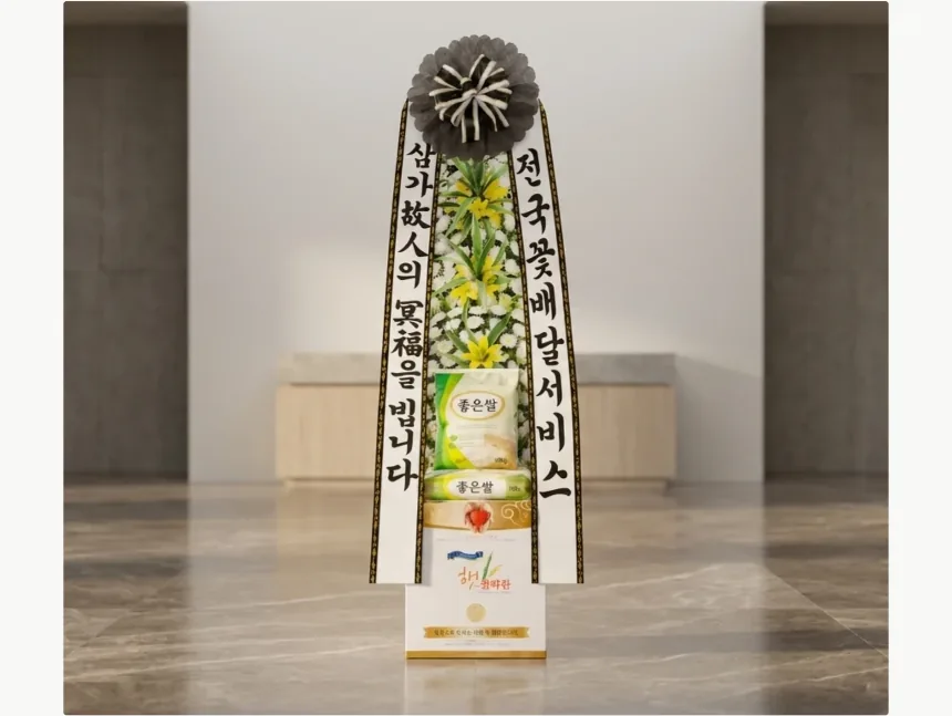 Sympathy rice wreath with white chrysanthemums and yellow lilies, holding two bags of rice, displayed at a funeral hall altar